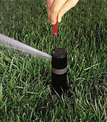 a hunter sprinkler head being adjusted with the adjustment key